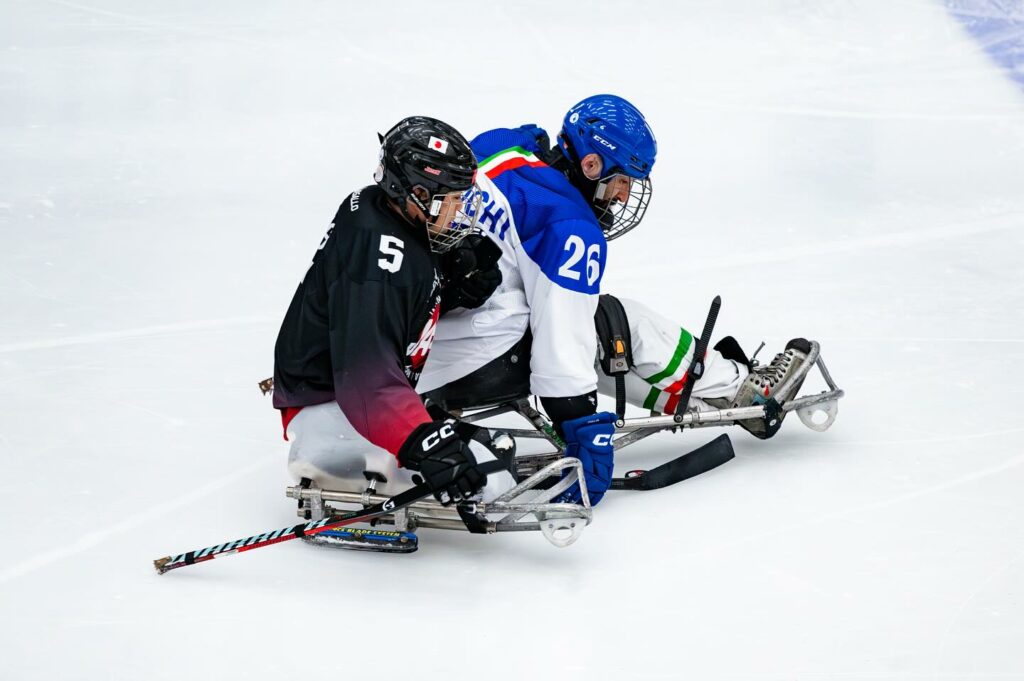 il difensore della nazionale italiana di para ice hockey eusebiu antochi in azione inseguito da un avversario